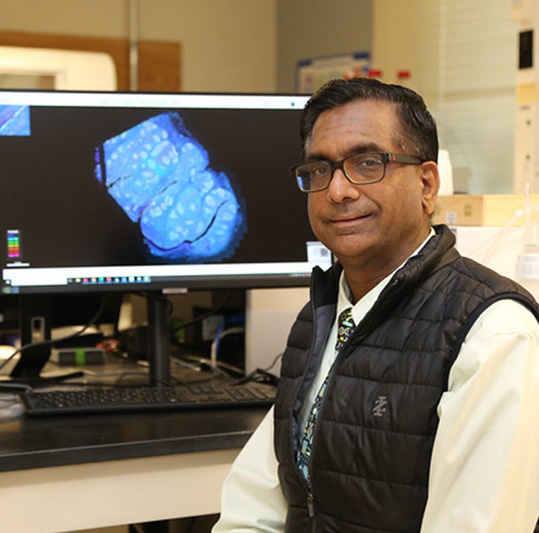 Anubhav Tripathi in lab beside computer