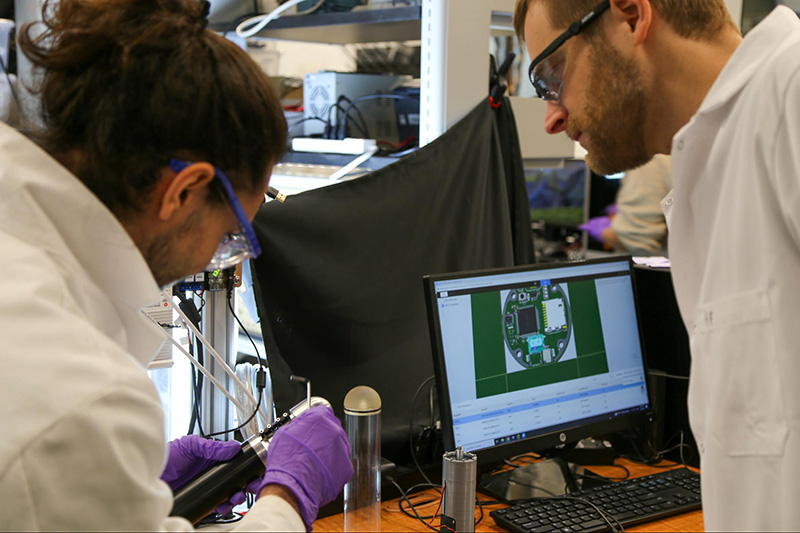 Harris in lab with student Antolik observing object